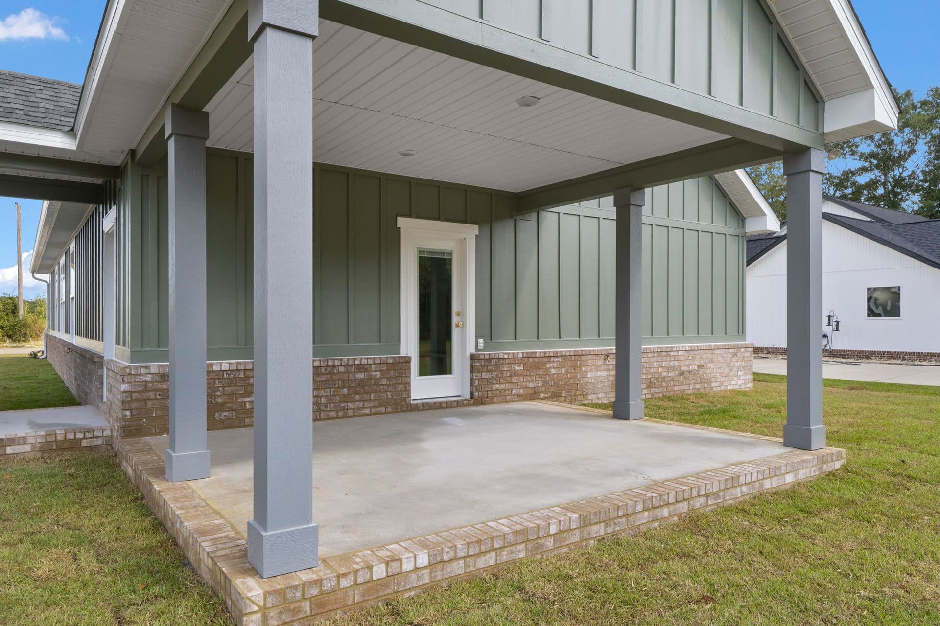 The deep covered rear porch of The Ashley on a brick-edged slab
