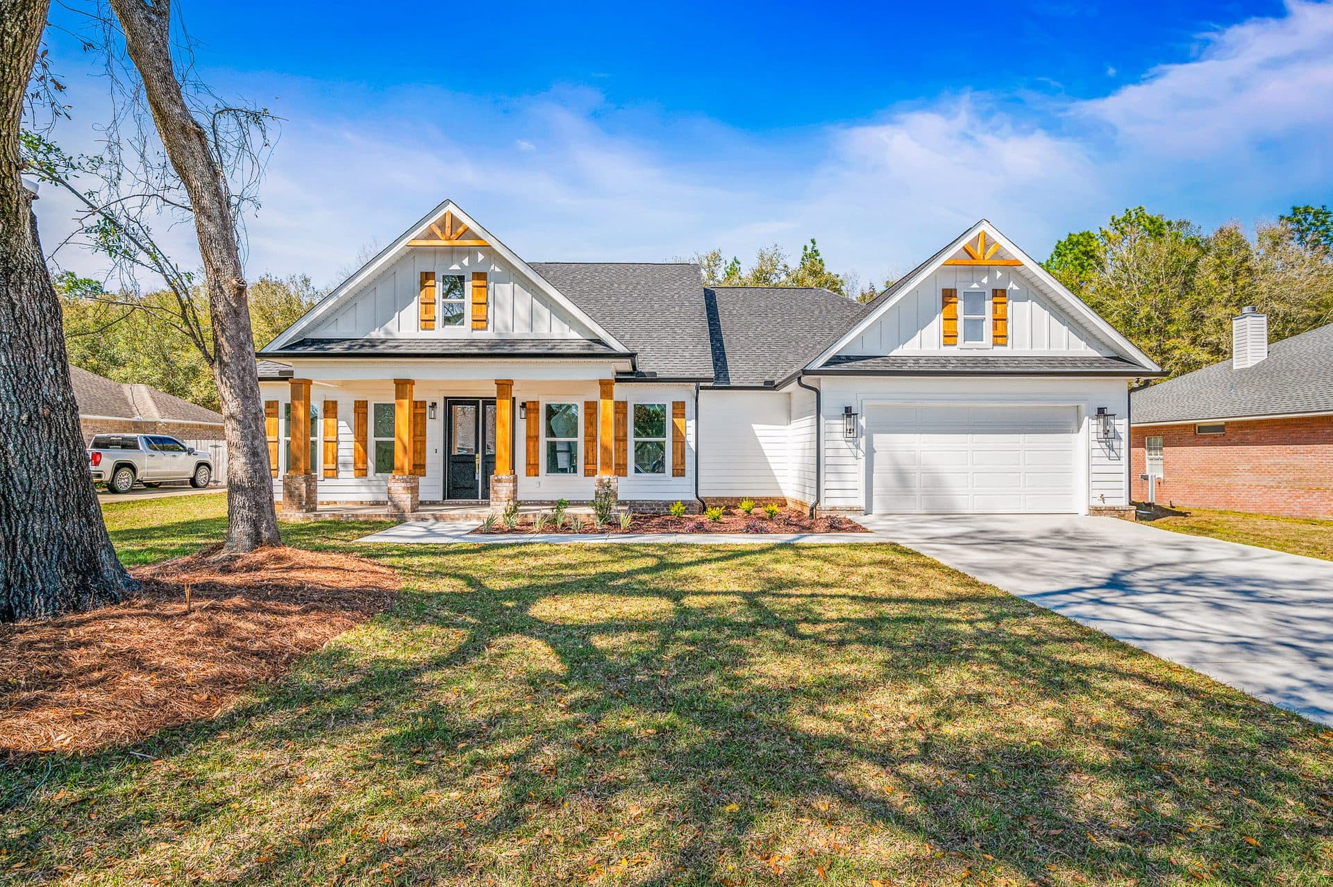 The Cameron, a single-story modern farmhouse with board-and-batten gables, white lap siding, cedar-toned porch posts and a 2-car garage