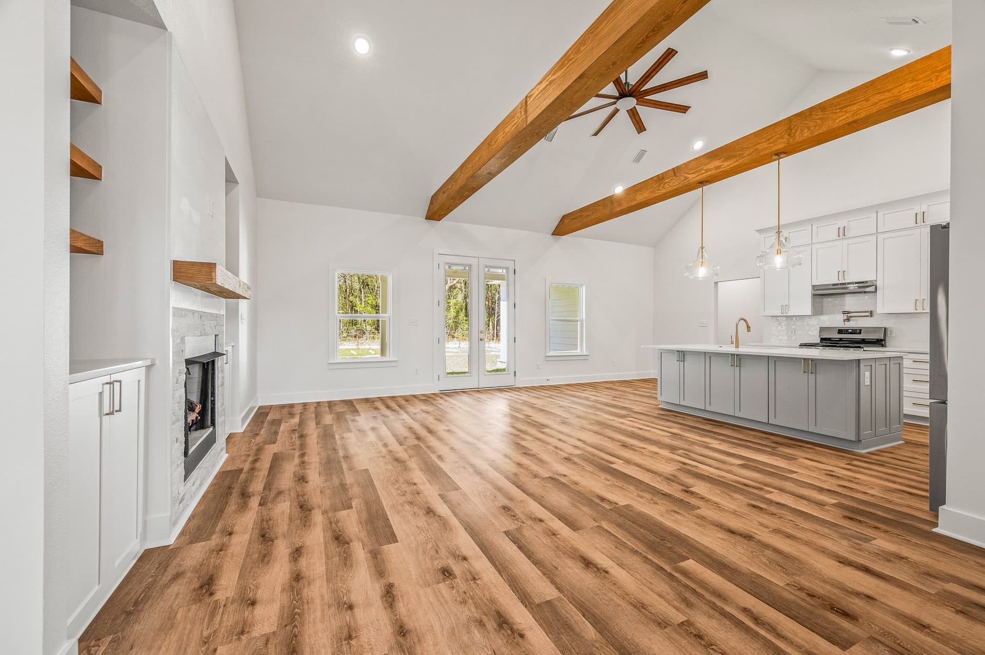 The Cameron great room with cedar beams on a vaulted ceiling and a fireplace between built-ins