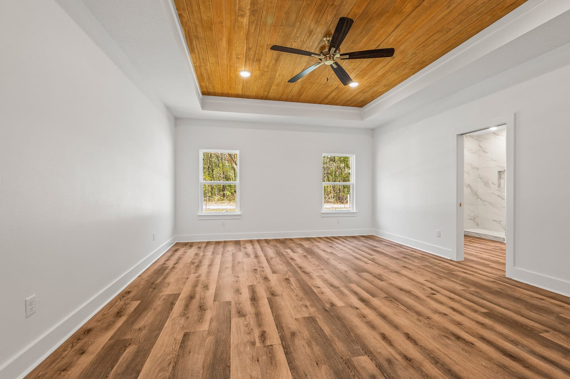 Primary bedroom in The Cameron with a tongue-and-groove wood tray ceiling